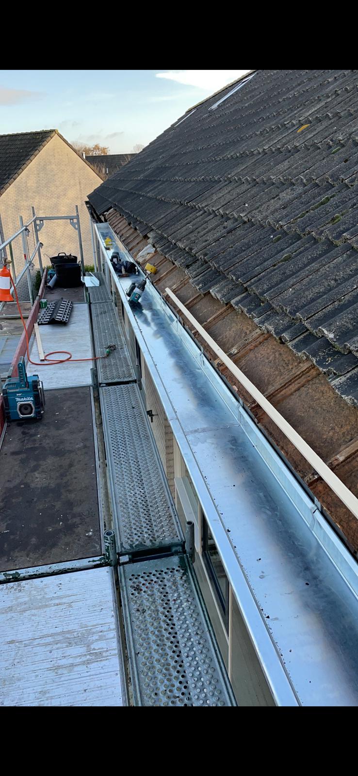 Nieuwe zinken dakgoot langs dakrand